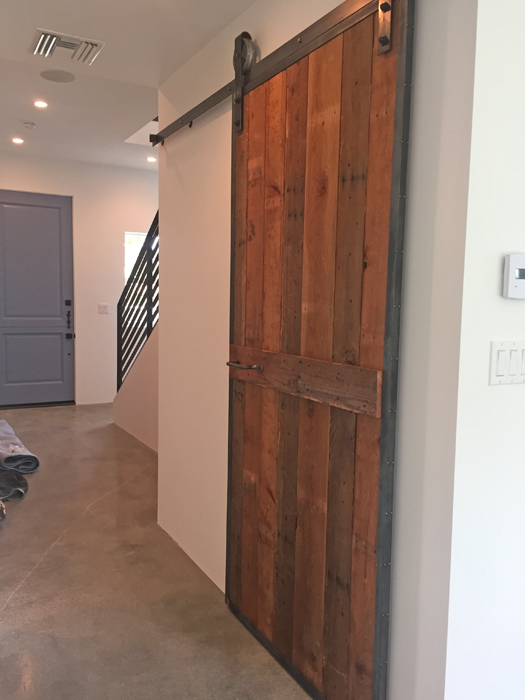 Downstairs sliding barn door at the Palm Modern Farmhouse. This door was fabricated with steel and wood from the original house.